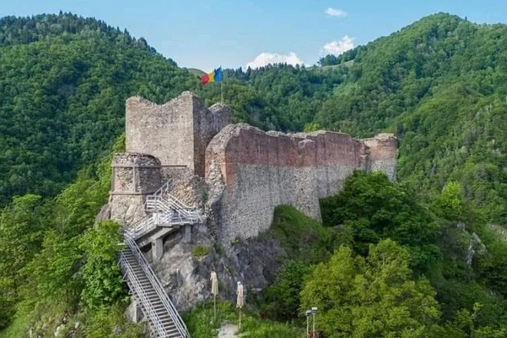 Ruinen der Burg Poenari mit wehender rumänischer Flagge.