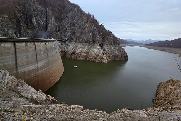 Blick auf die Vidraru-Talsperre und den Stausee unter einem bewölkten Himmel.